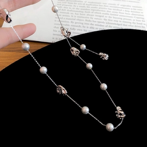 Close-up of grey pearls and irregular silver beads on a long layered necklace