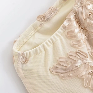 Vue détaillée de la broderie en ruban de velours champagne sur tissu jacquard
