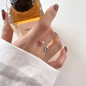 Detailed view of an irregular S925 sterling silver open ring on hand with elegant sleeve
