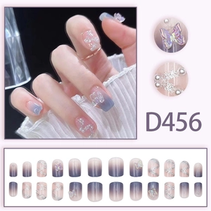 Macro detail of D456 press-on nails with 3D butterflies, pearls and glitter lines