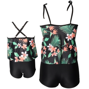 Front and back view of a two-piece floral tankini set with ruffle top and black swim shorts