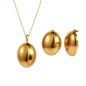 Polished gold jewelry set with oval pendant necklace and matching stud earrings