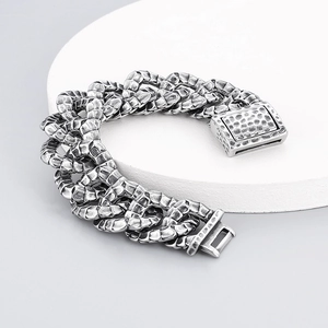 Vintage silver dragon scale Cuban chain bracelet with textured hammered finish on a stand