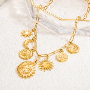 Close-up of gold sun and moon face charms on a rectangular link chain necklace