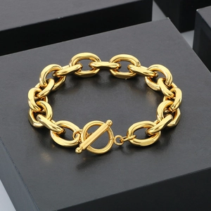 Golden stainless steel chunky Cuban link bracelet with OT toggle clasp on a black gift box