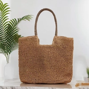 Detail of hand-woven straw tote bag with brown spiral-wrapped handles and natural texture