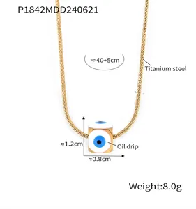 Detail der goldenen Schlangenkette aus Titanstahl und quadratischem Anhänger mit Emaille-Auge