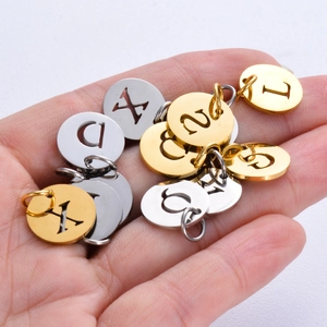 12mm stainless steel hollow round letter pendants in gold and silver held in hand