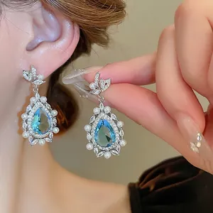 Blue water drop gemstone earrings with pearl border and crystal butterfly stud