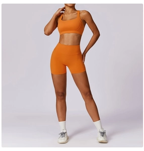 Dettaglio del reggiseno sportivo arancione elasticizzato e set di pantaloncini a vita alta
