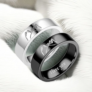Macro detail of titanium rings with hand-hook engraving and I love you inscription