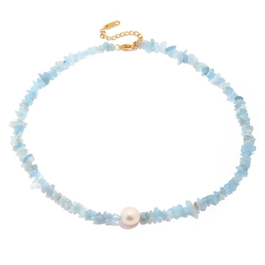 Detail of light blue crystal stone necklace with a central white pearl and gold clasp
