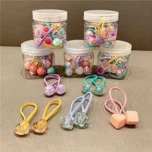 Macro detail of colorful heart and star hair ties stored in a clear plastic container
