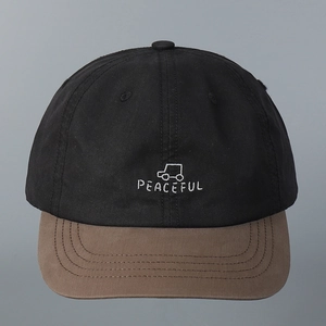 Detail view of the embroidered Peaceful car pattern on this casual contrast color baseball cap