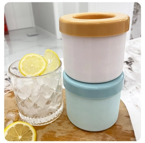 Detailed view of silicone ice cylinder molds with lemon water on a wooden tray