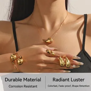 Close-up of a model wearing a golden teardrop jewelry set with sleek metallic finish