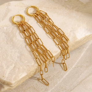 Boucles d'oreilles pampilles dorées avec chaîne trombone sur fond de pierre naturelle