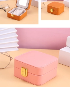 Detail of pink and orange jewelry boxes with velvet lining, mirror and secure metal lock