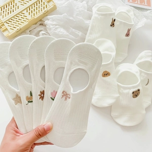 Detail of white cotton low-cut socks with varied animal embroidery like rabbits and dogs