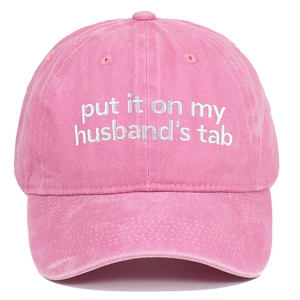 Detail of pink washed cotton baseball cap with white embroidered text on the front crown