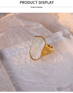 Dettaglio di un anello geometrico in oro 18K con un grande intarsio di madreperla bianca