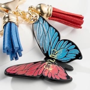 Fashionable butterfly keychain with red and blue oil drip pendant and matching tassels