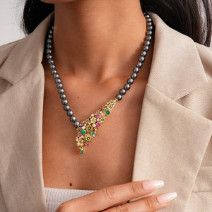 Detailed macro of vintage flower pendant with grey pearls and gemstones on the necklace