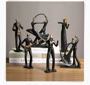 Statues de musiciens en noir et or disposées avec soin sur une surface en bois