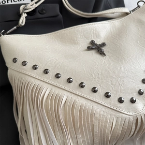 Creamy white leather crossbody bag with silver studs, cross emblem and long fringe details