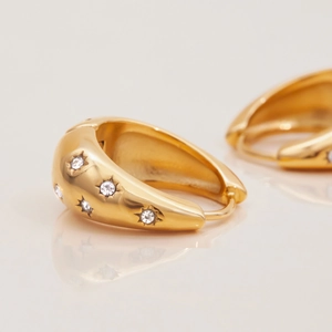 Dettaglio orecchini huggie placcati oro 18K con pietre di zirconia trasparente