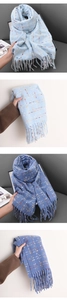 Close-up detail of soft plaid scarf fabric with long tassels in blue and yellow tones