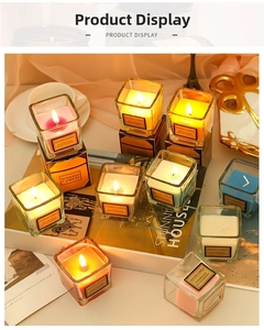 Close-up of colorful scented candles in square glass jars with elegant gift boxes