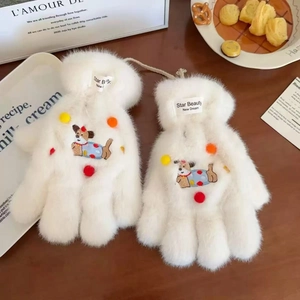 Detail of plush white winter gloves featuring a cute cartoon dog embroidery and colorful pom-poms