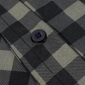 Macro shot of black four-hole buttons and high-quality grey plaid twill fabric texture