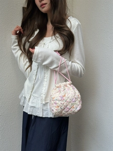 Close-up of quilted floral drawstring storage bag showing soft texture and pink handle