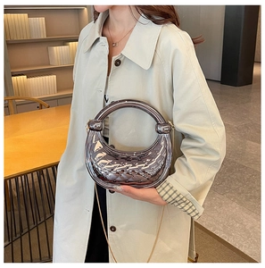 Silver crescent clutch bag featuring a high-gloss quilted texture and chain strap