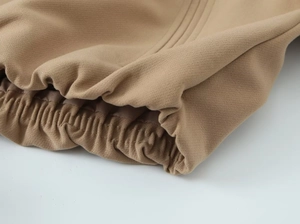 Détail des poignets élastiques d'une veste matelassée camel avec des coutures précises