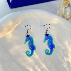 Detailed view of colorful iridescent seahorse earrings with a gradient metallic finish