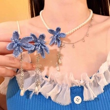 Dettaglio collana di perle da sposa con fiore ricamato blu e orecchini a nappa abbinati