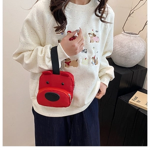 Detail of red cartoon bear handbag with black handle straps and cute puppy shape