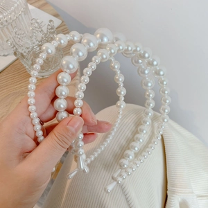 Detailed view of three vintage faux pearl headbands with glossy round beads and elegant design