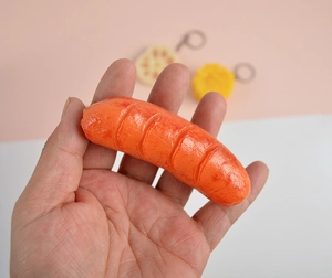 Close-up of realistic PVC hot dog keychain featuring detailed grill marks and glossy finish