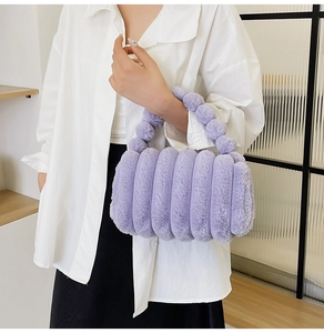Detailed close-up of a purple fuzzy plush handbag with soft striped texture and round handle