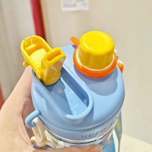 Close-up of blue plastic water bottle with dual drinking lids in yellow and orange