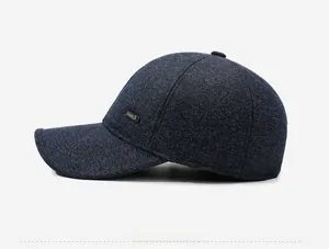 Detail view of the blue-black knit baseball cap featuring a metal Sport side badge
