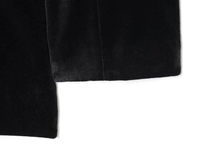 Detailed macro shot of the black velvet fabric texture on the V-neck jumpsuit sleeve