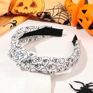 Detail of Halloween knotted headband with white fabric and black ghost patterns