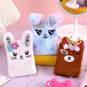 Detailed view of plush rabbit and deer notebooks with embroidery and crown sequins