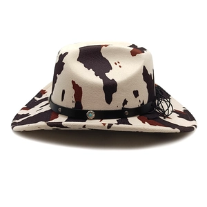Western cow print cowboy hat featuring turquoise stone accent and leather tassel detail