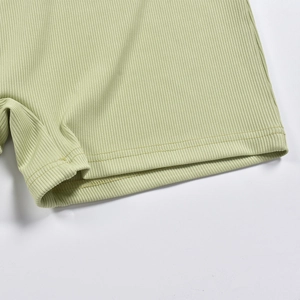 Close-up of light green ribbed knit fabric detail and precise stitching on the garment